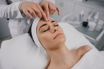 Naklejka premium Female receiving face massage of detox therapy, at the spa salon. Attractive beautiful girl. Beauty woman body. 