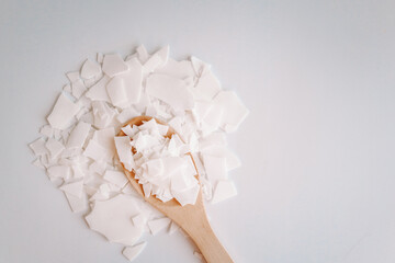 Soy wax on a wooden spoon. Natural, ecological, renewable, vegan. Soy candle wax