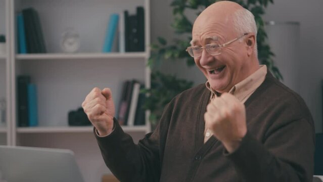 Emotional senior man going all-in and winning while playing poker online, winner