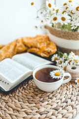 Open Bible and daisies on the windowsill, summer composition