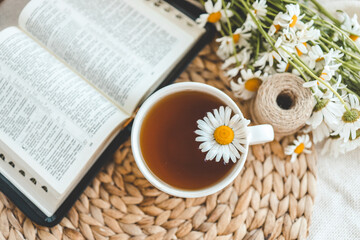 Open Bible and daisies on the windowsill, summer composition