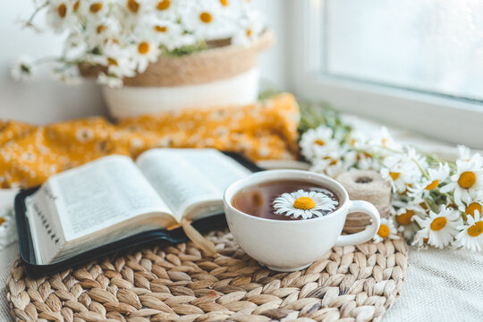 Open Bible and daisies on the windowsill, summer composition