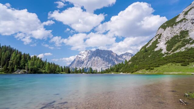 Timelapse video of a crystal clear alpine lake with a mountain range in the background. The Zugspitze, the tallest mountain in Germany, rises behind the Seebensee lake near Ehrwald in Tyrol, Austria.