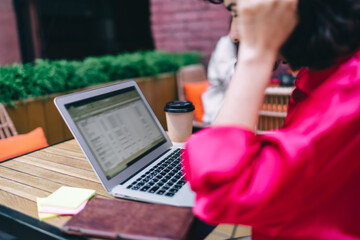 Crop woman working on netbook in cafe