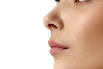 Cropped, close-up profile image of female face part, nose and lips against white studio background....