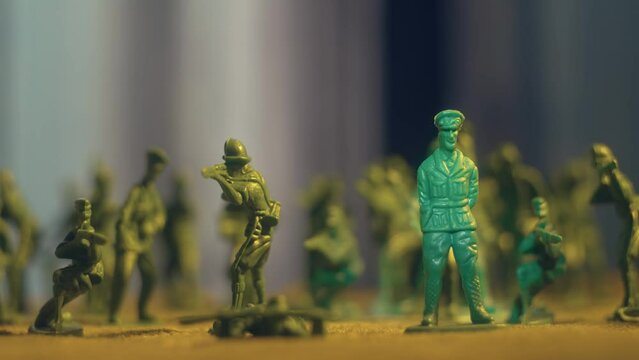 Army general surrounded by armed toy soldiers with spotlight effect. Violence war resistance and peace without armored invasion