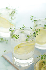 Glasses with lemon and thyme refreshing drink	