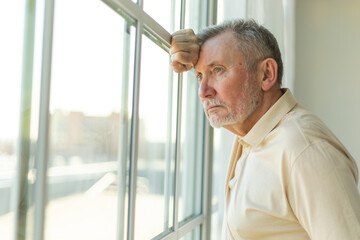 Sad tired lonely disappointed older senior man at home alone. Unhappy grandfather looking sadly...