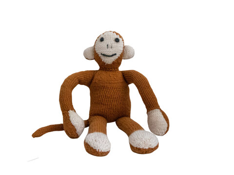 Hand knitted sitting monkey toy. The brown monkey isolated on transparent background. PNG image.