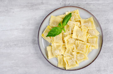 Tasty Appetizing Ravioli with Cheese and Basil on a Plate, Grey Background