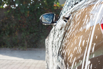 Naklejka na ściany i meble Car washing at the car wash shop.