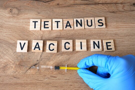 Tetanus vaccine concept. Hand in gloves is taking syringe.
