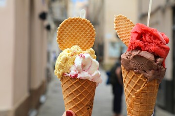 Ice cream in Alghero, Sardinia. Hand holding Italian gelato ice cream in cone. - obrazy, fototapety, plakaty