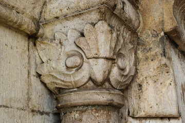 old stone column head closeup. fine details and texture. artistic carving. ornamental aztec eagle head pattern.  history and culture concept. wall art image. building and architecture. 