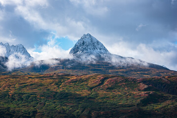 View of mountain peak surrounded by clouds in Alaska, USA.