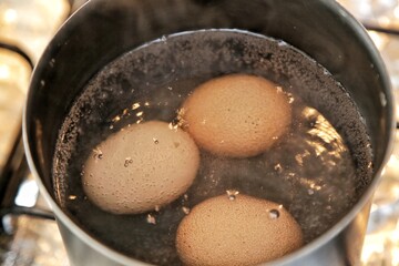Ovos na panela fervendo com bolhas de água cozido.