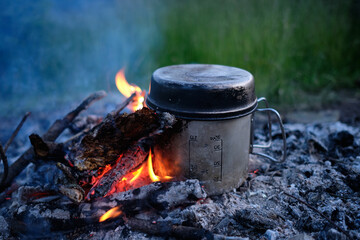 Making coffee or tea on the fire of nature. Burning fire. A place for fire. Ashes and coal.Active Lifestyle Concept.