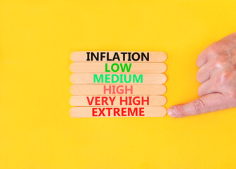 Extreme inflation symbol. Concept word Inflation low medium high very high extreme on wooden sticks. Businessman hand. Beautiful yellow background. Business extreme inflation concept. Copy space
