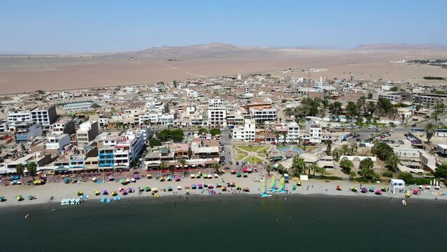 Aerial shot drone flies to the right with Paracas beach in the foreground and the desert in the background
