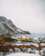 Scenic buildings and houses in Nusfjord, Lofoten Islands, Norway—Mesmerizing winter landscape with scenic building, mountains, water, and snowy surroundings.