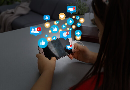 Close-up of smartphone in female hands. In foreground are virtual icons with picture of clouds, people and digital gadgets. Social media. Girl blogging, chatting online. Cloud technology.