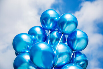 blue balloons on nature blue cloudy sky background. Party and celebration concept