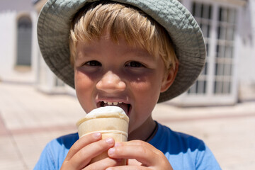 little boy 3 years old eats ice cream and smiles