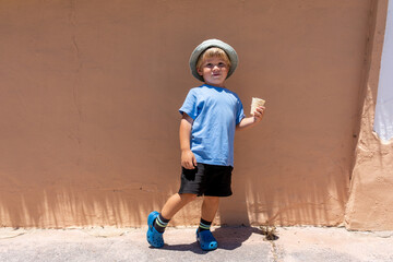 little boy 3 years old eats ice cream and smiles