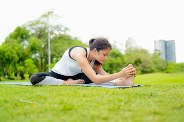 Pleasant millennial woman practice yoga outdoor in the morning during wellness retreat.