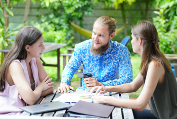 Young office worker presenting new financial plan to his partners during a meeting