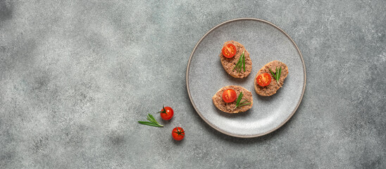 Toast with liver pate in a plate on a gray background. Open sandwich with liver pate. Top view, flat lay, banner - obrazy, fototapety, plakaty