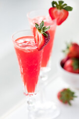 Refreshing strawberry Mimosas garnished with fresh cut strawberries.