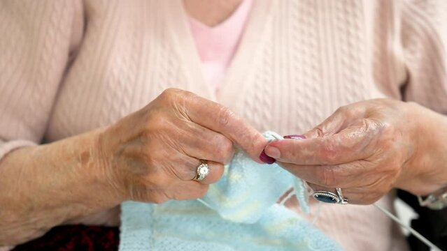 Elderly woman crocheting in a handicraft course as a hobby or occupational therapy at nursing home. High quality 4k footage