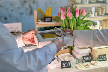 experienced artisan presents a meticulously crafted, handmade candle. Embracing Artisanal...