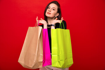 Fototapeta na wymiar Attractive stylish woman holds bags in her hands after shopping at the mall