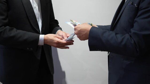businessman giving or receiving money, giving cash bill bank notes hand to hand, men wearing suit paying with mexican pesos