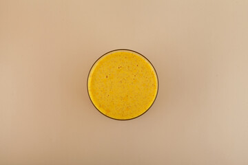 Glass of Golden Milk, top view. Turmeric latte with milk and honey to support the immune system....