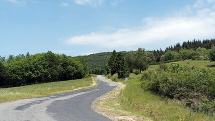 Fototapeta na wymiar Paysage de la Montagne Bourbonnaise entre Loire et Allier. Petites route sinueuse entre La Loge des gardes et la Chabane 