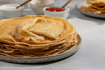 Crepes on gray table . Thin pancakes served with jam and sour cream.