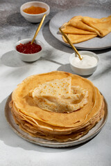 Crepes on gray table . Thin pancakes served with jam and sour cream.