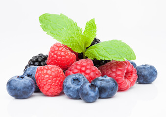 Fresh blueberry raspberry and blackberry with mint leaf closeup on white background