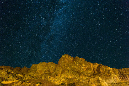 Starry night sky over rocky hilly terrain landscape in high desert Central Oregon