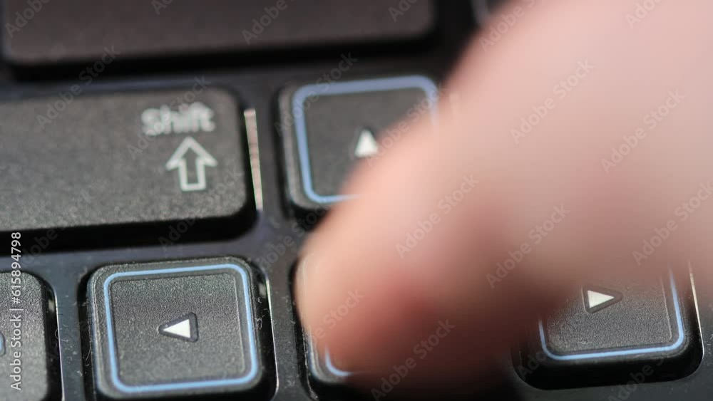 Poster finger presses on the arrow button on the laptop keyboard