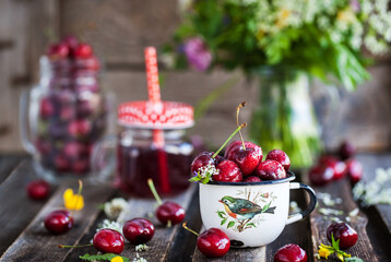 Fresh wet cherry in enamel metal mug, summer concept
