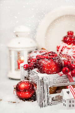 Holiday Christmas composition with red apples, balls, cinnamon, snow and candles