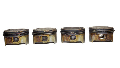 car engine pistons set. partially disassembled. equipped with gap rings, shows piston pin holes and oil control groove with drain holes, on white background, in a line