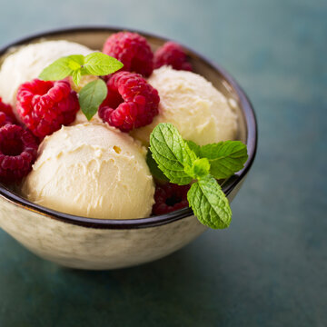 Homemade organic ice cream with fresh raspberries and mint. Frozen yogurt.