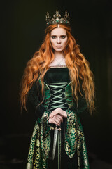 Fototapeta premium Portrait of a beautiful red-haired woman in green medieval dress