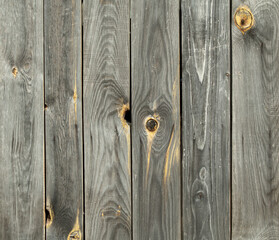 Contrasting wooden background from old weathered pine boards with cracks and knots