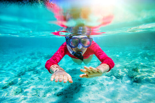 Girl swimming underwater in clear tropical waters